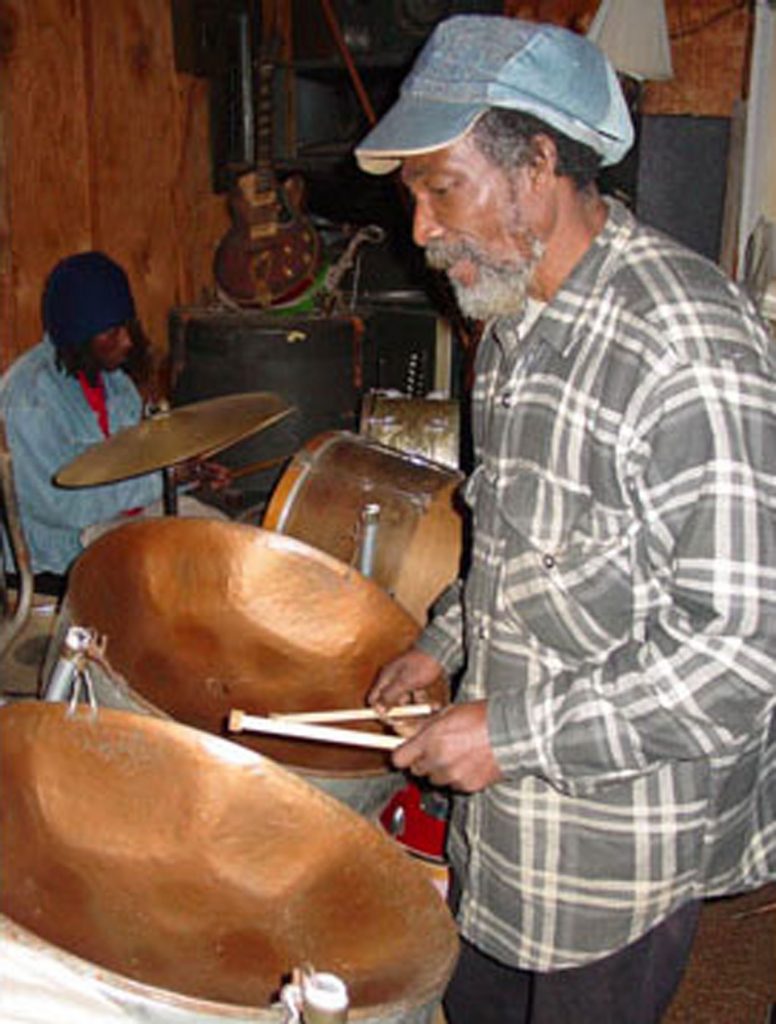 Hugh Addison of Jackson performing on the steel drums. His son Damian (back left) is backing him up on drum set.