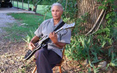 Ealey with guitar in front yard.