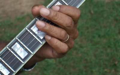 Close-up of Williams playing guitar.