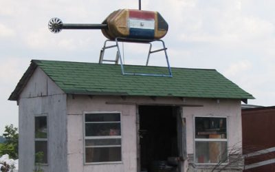 Shed with helicopter sculpture on top.