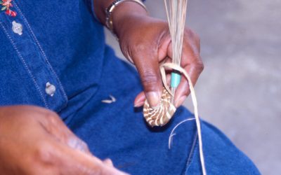 Close-up of Johnson starting a pine straw tray. The pine straw is held together with a small plastic sleeve.