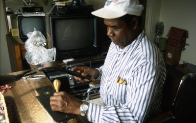 Chism punching holes in a bottle cap. Coat hangers and other scrap wire is run through the holes to hold his pieces together.