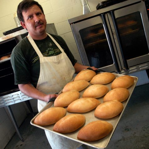 Jose Flores from Panaderia Nuevo Leon in Vardaman removes a tray of bolillos (white bread) from the baking oven (photo by Kate Medley for the Mississippi Arts Commission).