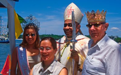 1999 Shrimp Queen and King pose with Bishop Joseph Howze (center). The person in front was a member of a German TV crew covering the event.